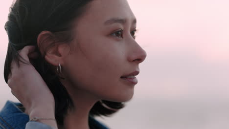 portrait of beautiful asian woman smiling enjoying carefree lifestyle exploring freedom on vacation looking happy with wind blowing hair