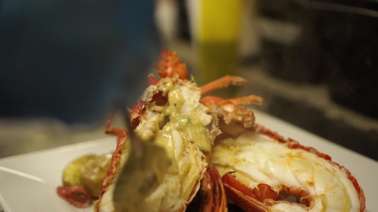 slowmo - 클로즈업 - 조리된 뉴질랜드 가재에 그레이비를 얹습니다.