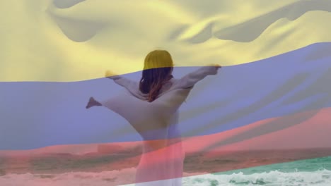 Zusammengesetztes-Video-Einer-Schwenkenden-Columbia-Flagge-über-Einer-Kaukasischen-Frau,-Die-Sich-Am-Strand-Amüsiert