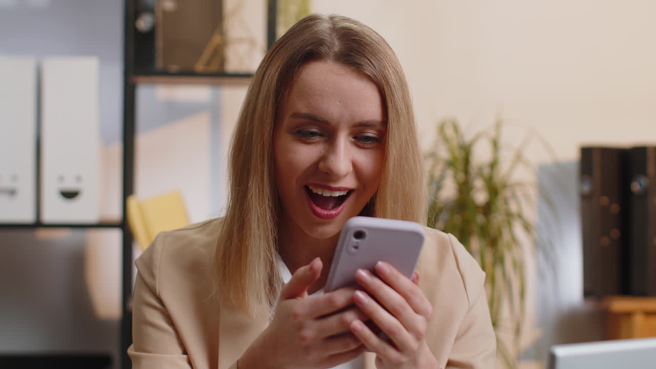 Businesswoman shocked by sudden victory on smartphone game winning lottery goal achievemen good news