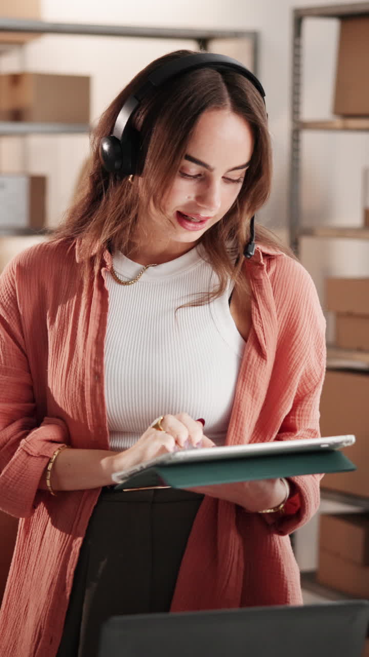 Young Woman Working on Tablet with Headset in Warehouse