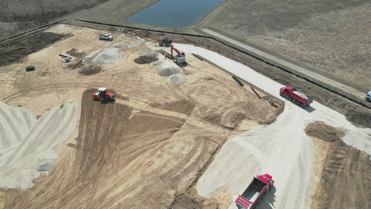 Top Down Aerial Construction site: dump truck, excavator, bulldozer, and forklift working on a new development project in Ozaukee County, Milwaukee, Wisconsin