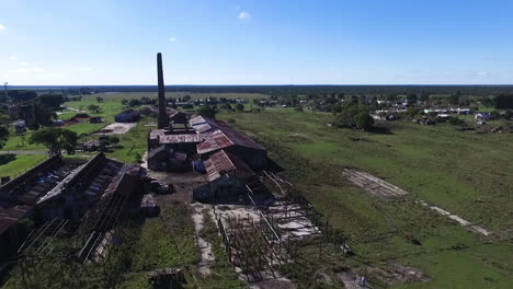 flying above old abandoned wood work factory, countryside landscape of argentina aerial view