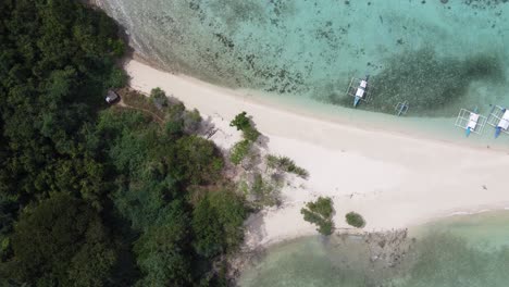 Sandbank-stretching-out-of-tropical-island-into-clear-blue-lagoon,-Drone-top-down