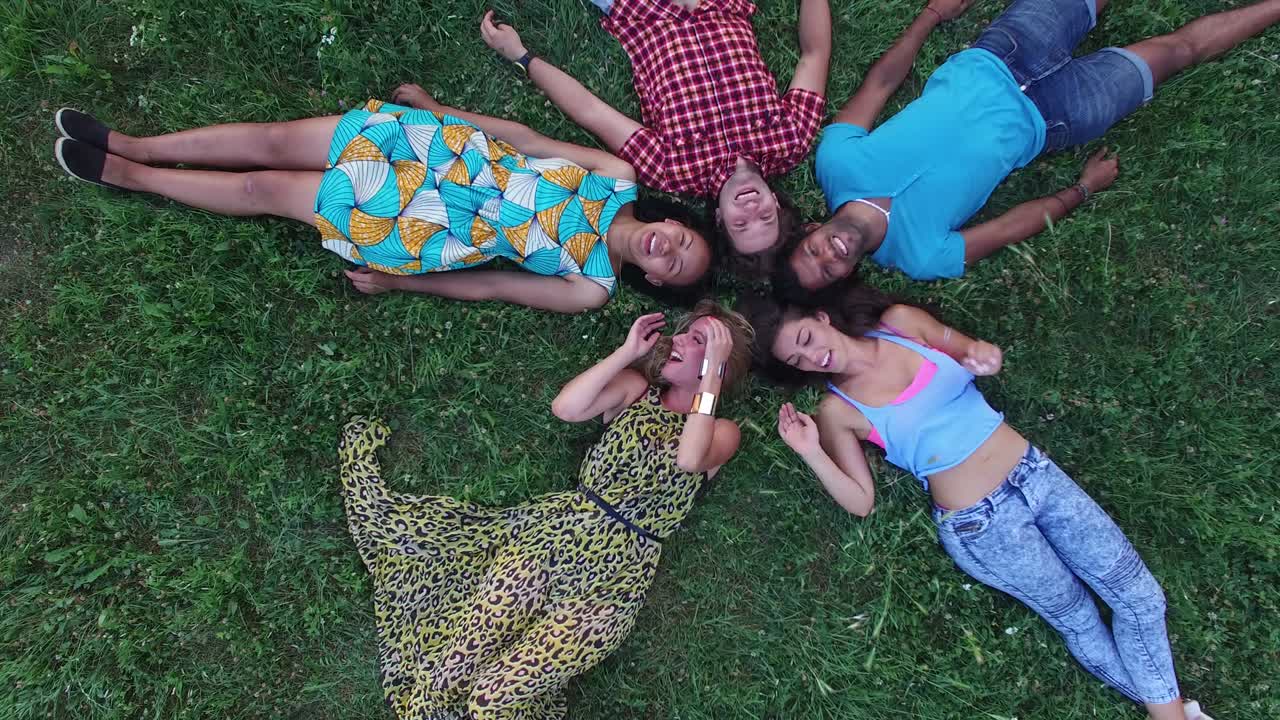 잔디에 누워있는 별 모양을 형성하는 친구 그룹의 안테나