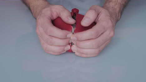 Close-up-of-hands-opening-moneybox