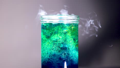 reacción líquida colorida con humo y burbujas