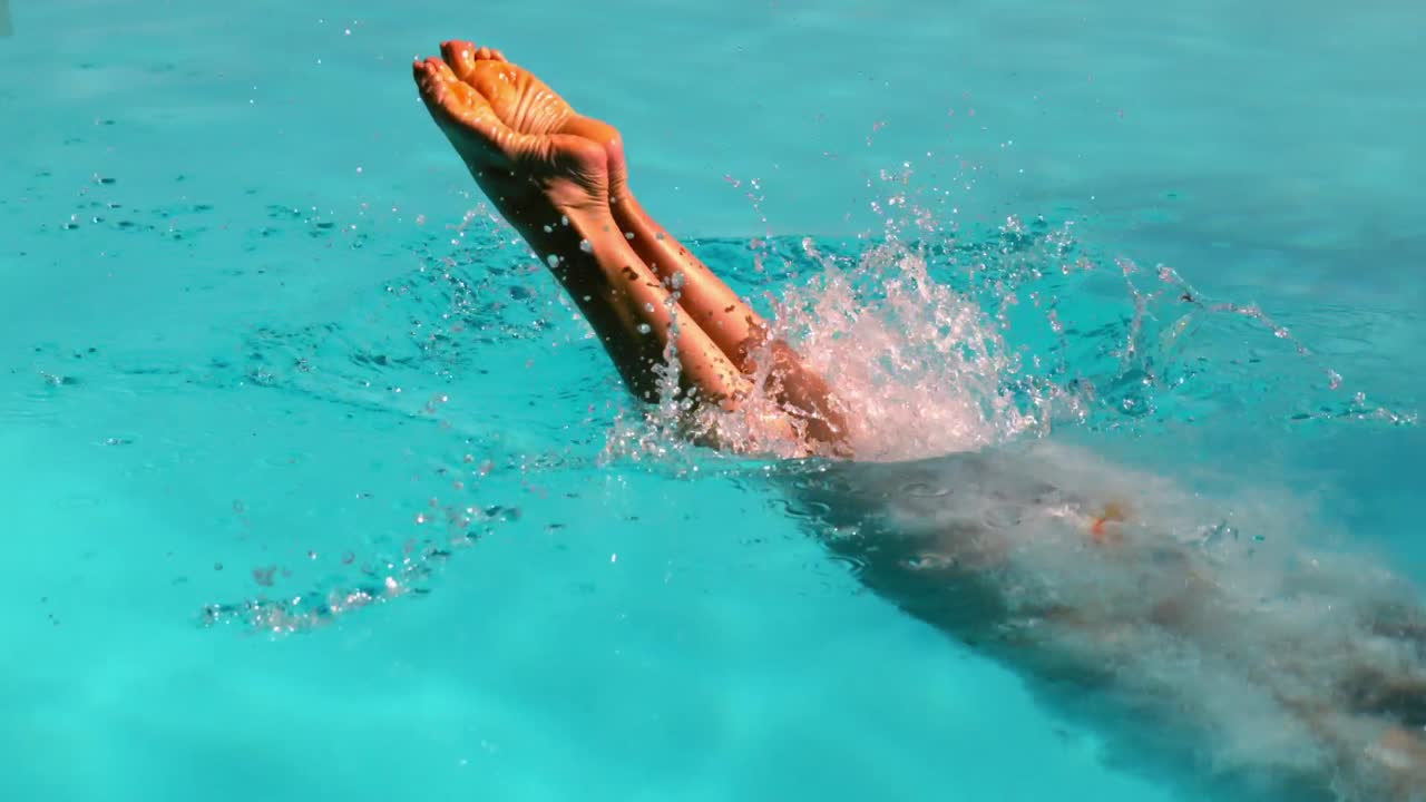 Bionda attraente che si tuffa in piscina