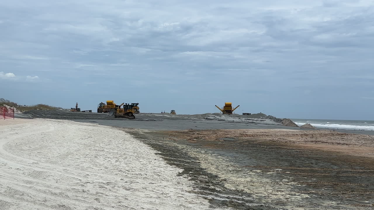 Wide view, beach replenishment equipment pumping and spreading sand