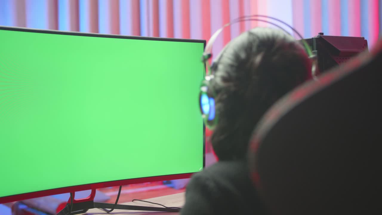 Young Gamer Girl Seating On The Chair With  Green Screen Computer While Playing Game