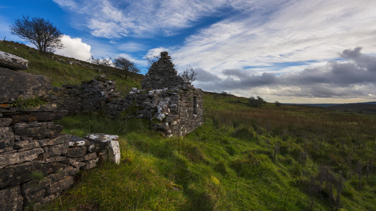 timelapse de la naturaleza rural tierras de cultivo con ruinas de muros de piedra abandonados en primer plano durante un día soleado y nublado visto desde carrowkeel en el condado de sligo en irlanda