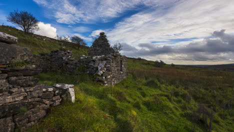 Timelapse-of-rural-nature-farmland-with-abandoned-stonewall-ruin-in-the-foreground-during-sunny-cloudy-day-viewed-from-Carrowkeel-in-county-Sligo-in-Ireland