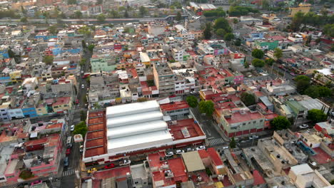 Vuelo-Aéreo-Sobre-Los-Edificios-De-Viviendas-Del-Barrio-De-Salvador-Diaz-Con-Automóviles-Circulando-En-El-Tráfico-Por-Carretera