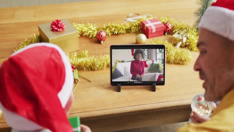 Kaukasischer-Vater-Und-Sohn-Mit-Weihnachtsmützen-Nutzen-Tablet-Für-Weihnachtsvideoanruf-Mit-Frau-Auf-Dem-Bildschirm