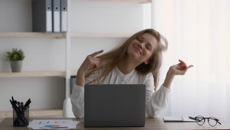 mujer feliz bailando en su escritorio