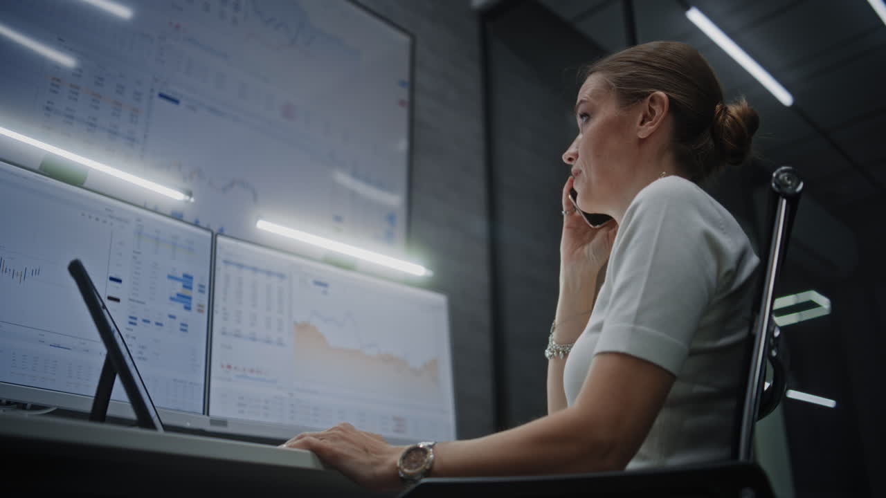 Businesswoman on phone call in office, reviewing financial data