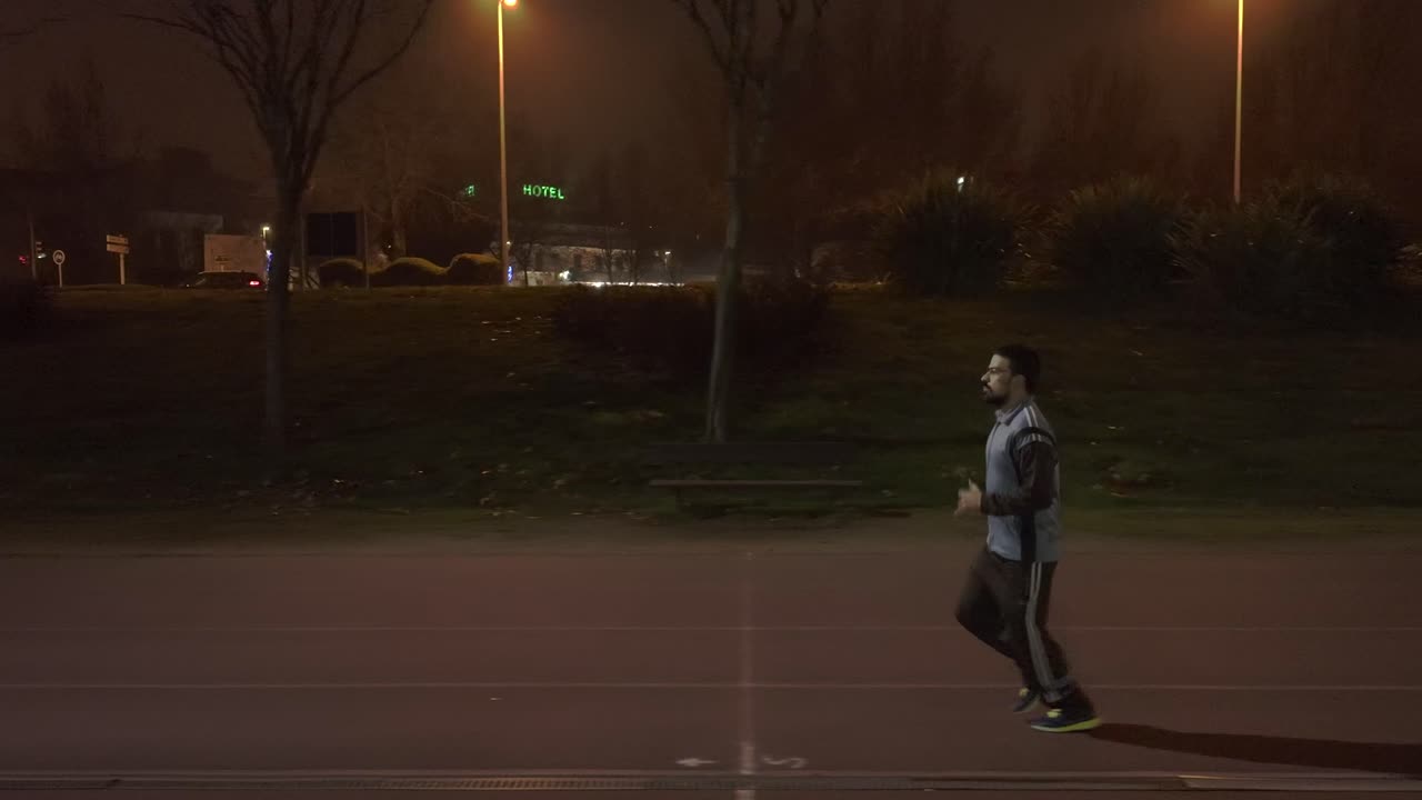 Tracking shot of athletic man Jogging at night time in Salamanca city, Spain