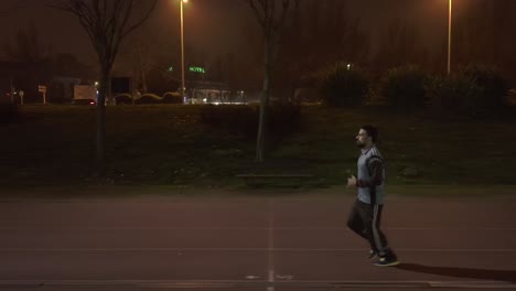 tracking shot of athletic man jogging at night time in salamanca city, spain