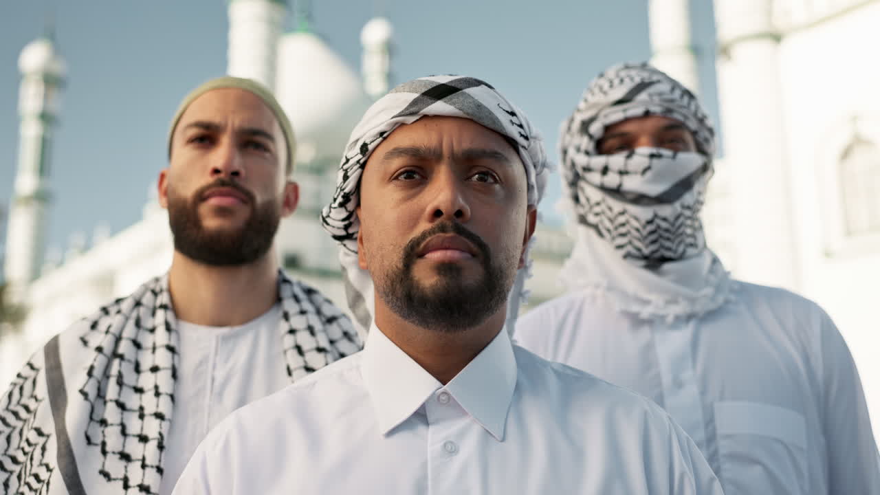 Group of men in traditional Islamic attire in front of a mosque