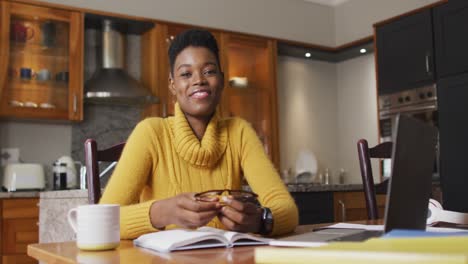 retrato de una mujer afroamericana sonriendo mientras trabaja desde casa