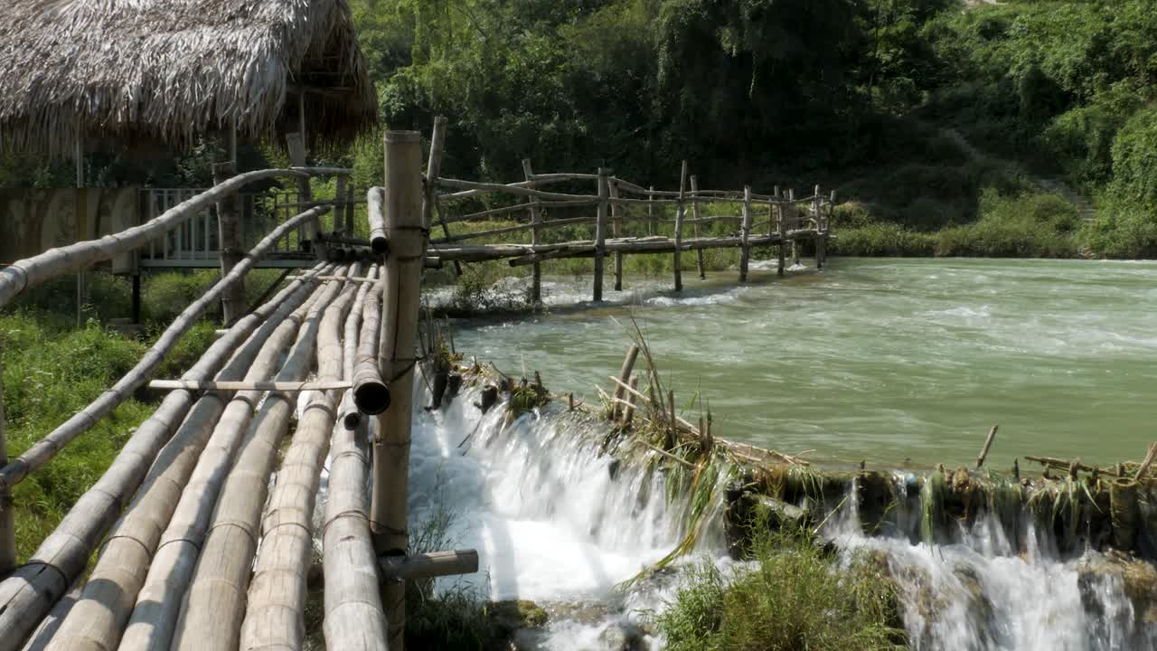 el puente de madera se extiende sobre la cascada, mezclándose armoniosamente con la naturaleza.