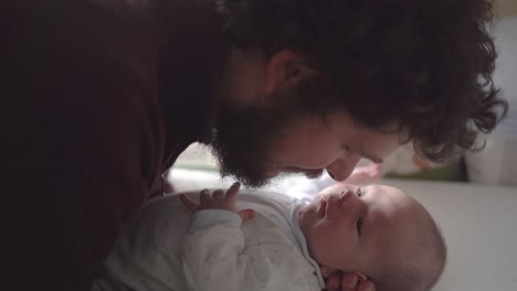 father interacting with newborn baby at home