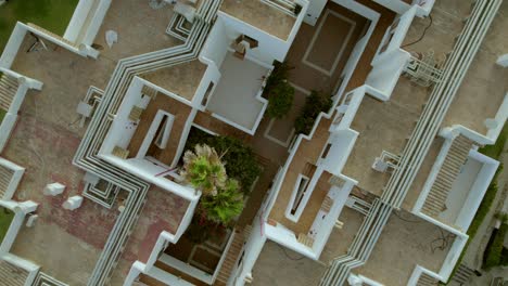 A-top-view-aerial-perspective-captures-the-rooftops-of-a-tourist-accommodation-building-in-Mallorca,-Spain,-emphasizing-the-essence-of-travel-and-vacation-concepts