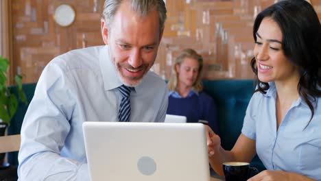 Woman-and-businessman-interacting-with-each-other-while-using-laptop