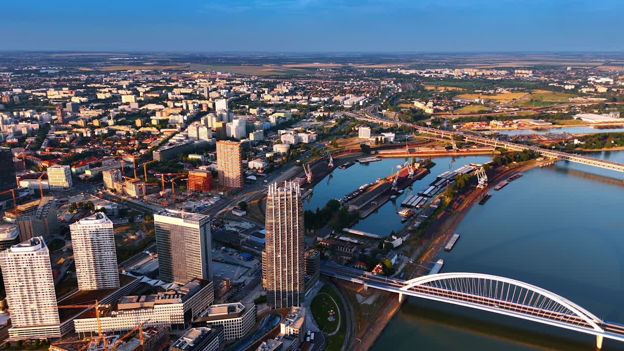 Vast sunlit panorama of modern Bratislava, Slovakia. Drone footage over the Danube River. Aerial view