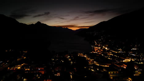 sunset remains over queenstown central at night, new zealand, aerial drone view