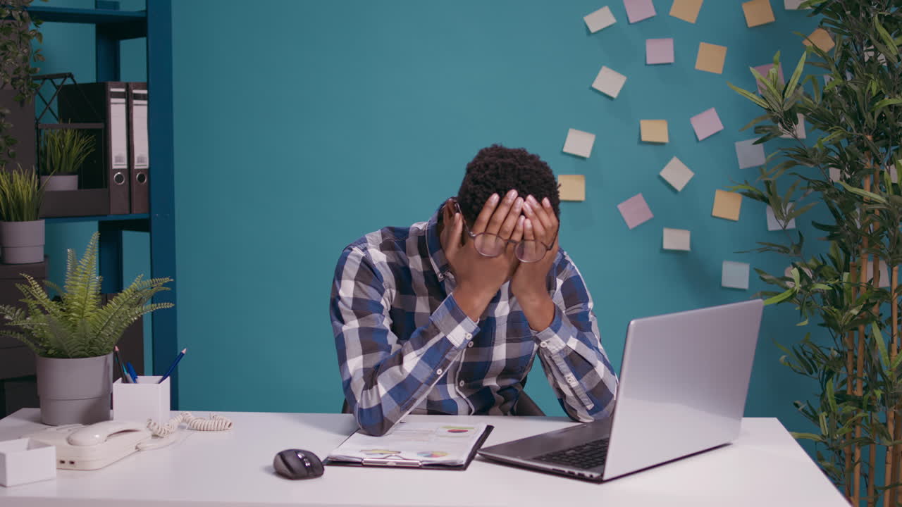 Desperate employee working on laptop computer at desk