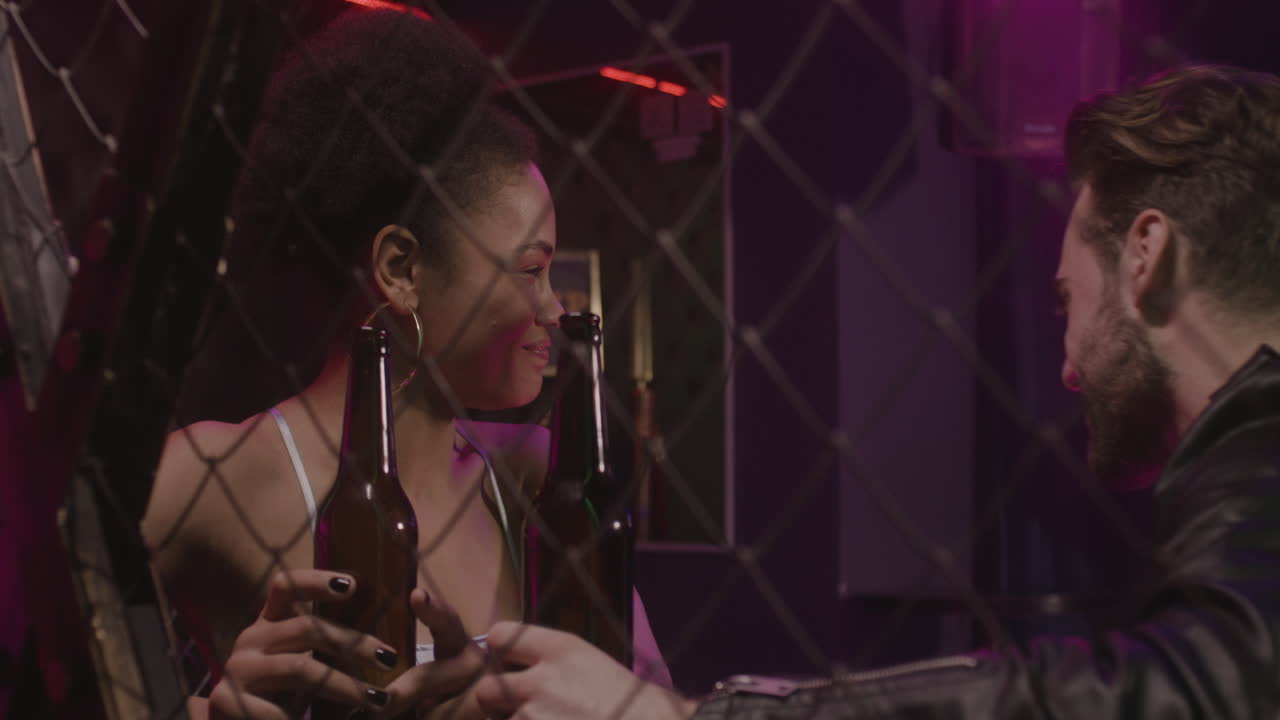 hermosa chica y hombre barbudo hablando y riendo juntos en la discoteca 1