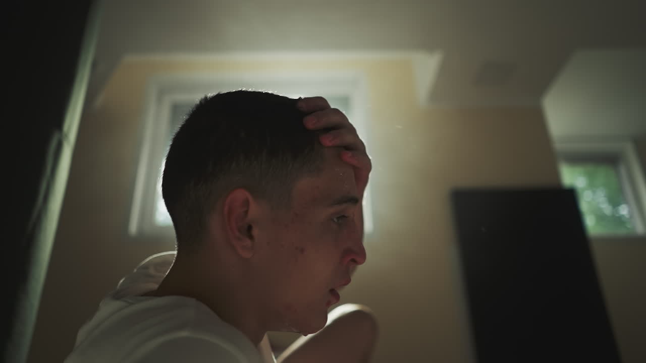 엄격한 권투 세션 후에 피곤한 남자는 을 흔들고 이 어지게합니다. 어두운 스포츠 클럽의 바닥에 물방울이 아집니다. 스포츠에 참여하는 데 대한 피곤함.