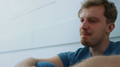 crying doctor sitting corridor after bad day close up. medic resting in hallway.