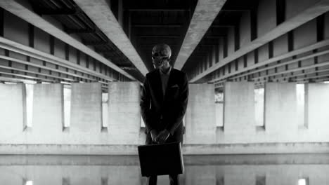 businessman in skull mask under a bridge