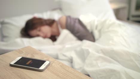 mobile alarm wake up woman in bed. wake up time in morning. female new day