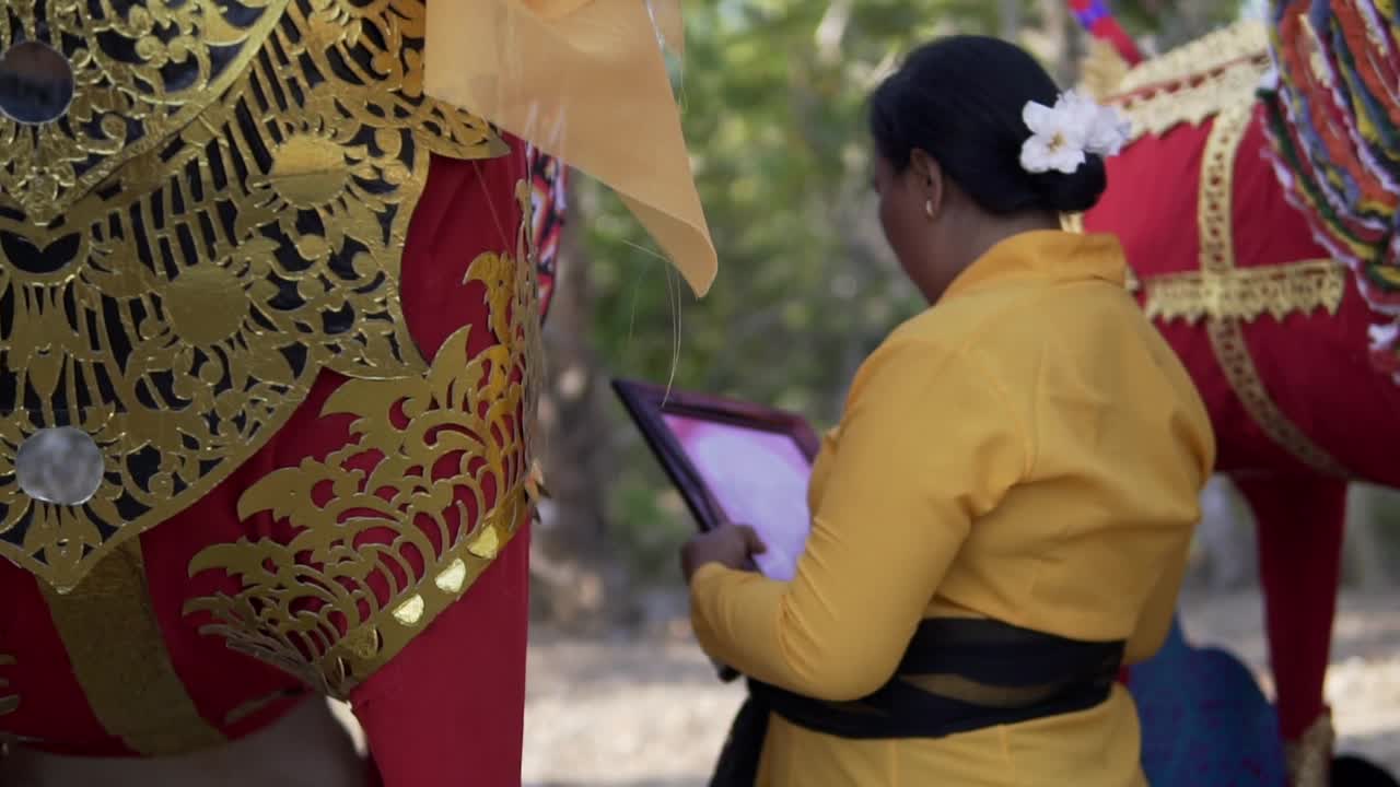 Woman looking at photo of a dead family member in a traditional Balinese funeral ceremony