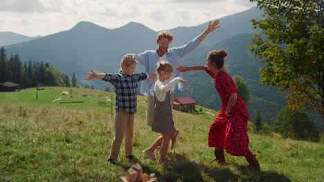 family having fun summer mountains. happy parents enjoying active funny games.