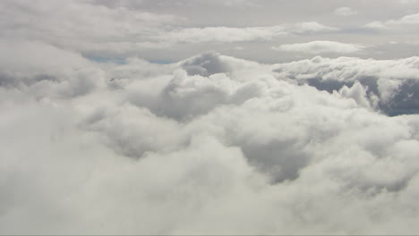 helicopter shot above large formations of white fluffy clouds