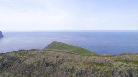 drone flying over a ridge with a hiking trail to reveal a arctic landscape and cliffs