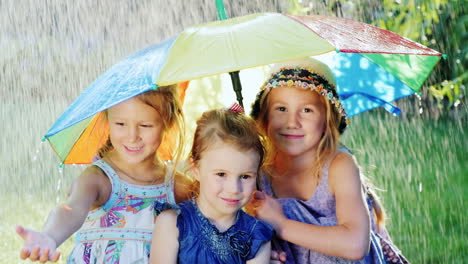 Three-Sisters-Are-Hiding-Under-The-Umbrella-Of-Color-There-Is-A-Warm-Summer-Rain-The-Children-Are-Ha