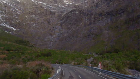 driving on state highway 94 near homer tunnel towards milford sound fiordland national park in south island, new zealand