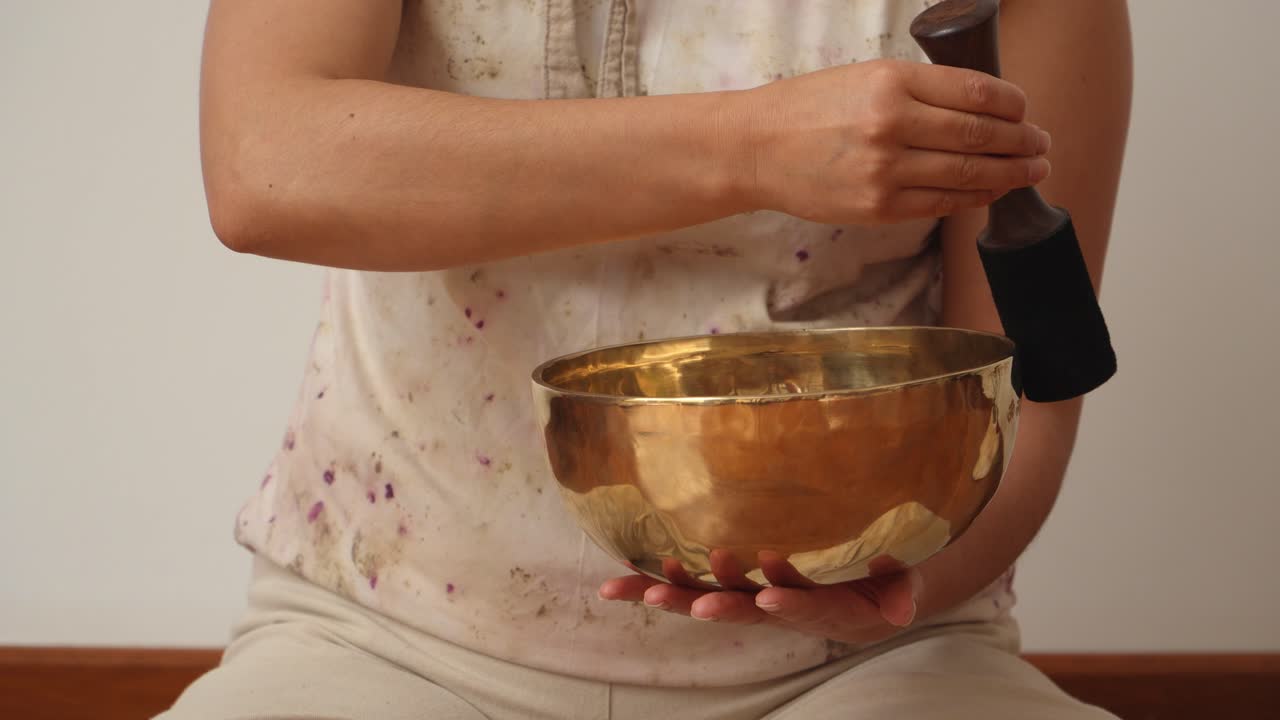 Tibetan singing bowl being played by woman musician