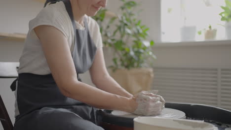 close-up of the hand of a master working on a potter's wheel for the manufacture of clay and ceramic jugs and plates in slow motion