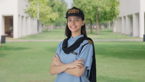 portrait of happy indian female security guard standing crossed hands