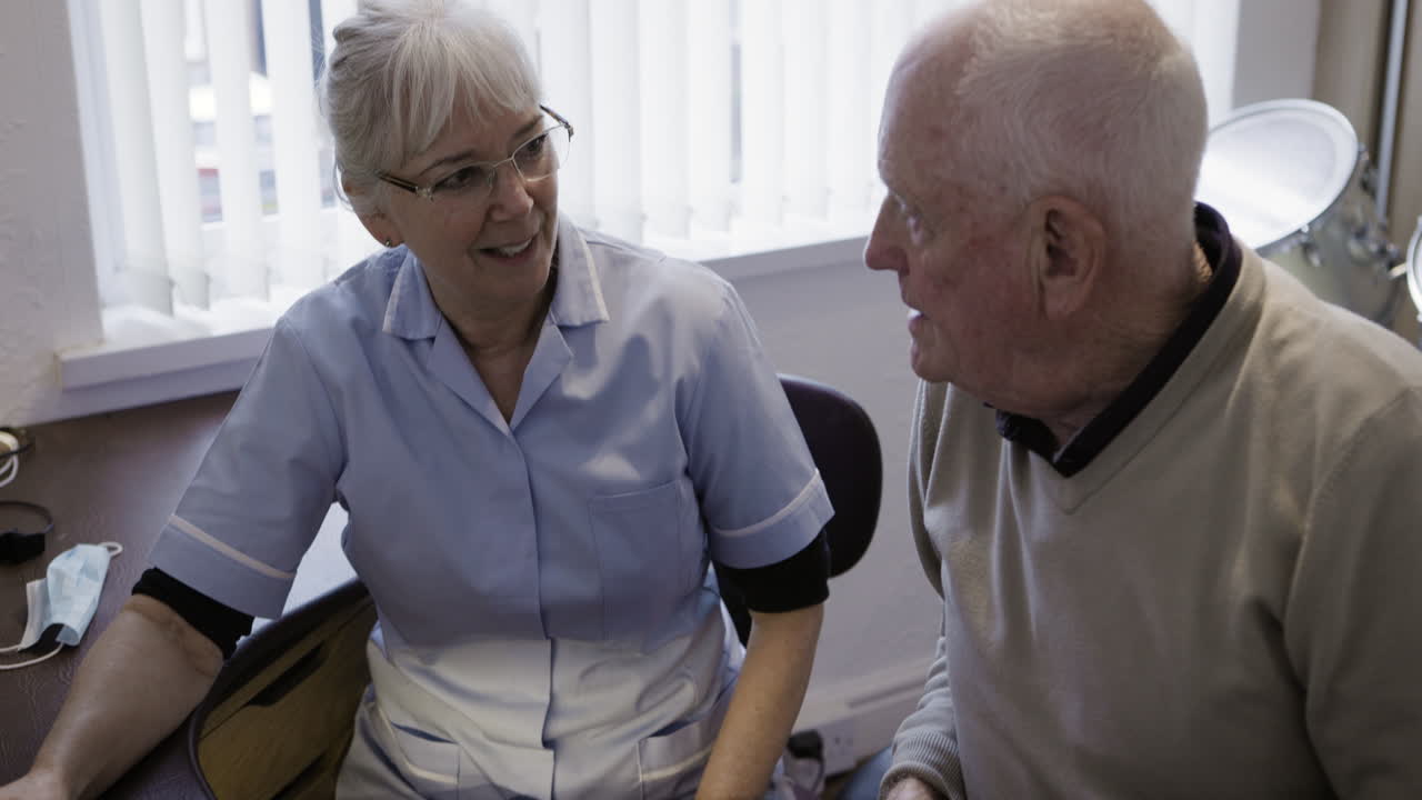 Nurse and senior man in conversation