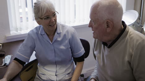 nurse and senior man in conversation