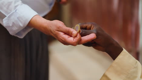 Hands-Of-Two-Persons-Exchanging-Algerian-Dinar-Coins-At-The-Market-In-Ghardaia,-Algeria