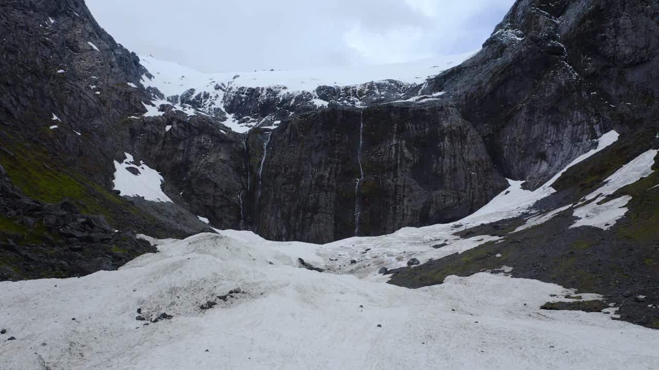 aire sereno por encima de la extensión helada, mirando hacia el majestuoso acantilado de la montaña en fiordland, nueva zelanda, isla sur