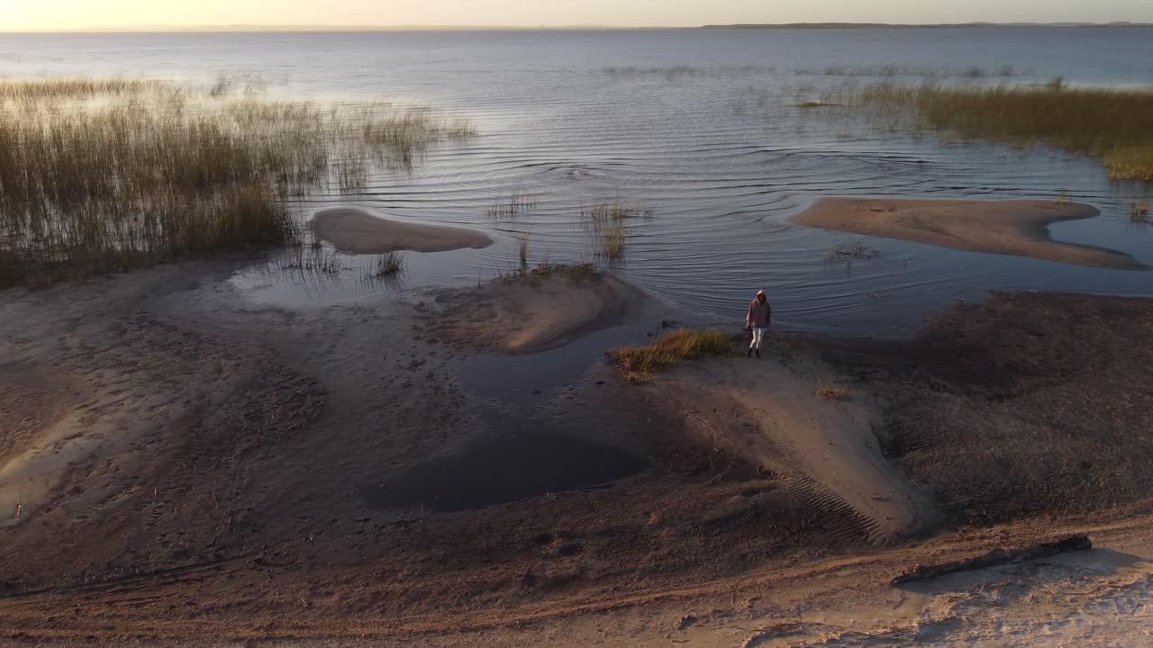 persona aislada en la orilla del lago al atardecer, laguna negra en uruguay